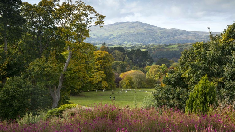 A view of the lawn and Snowdonian foothills in the distance at Bodnant Garden, Conwy